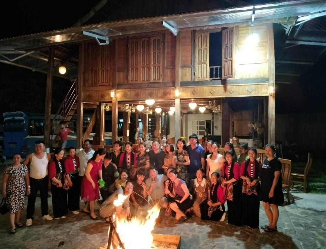 A group of people standing around a fire

Description automatically generated