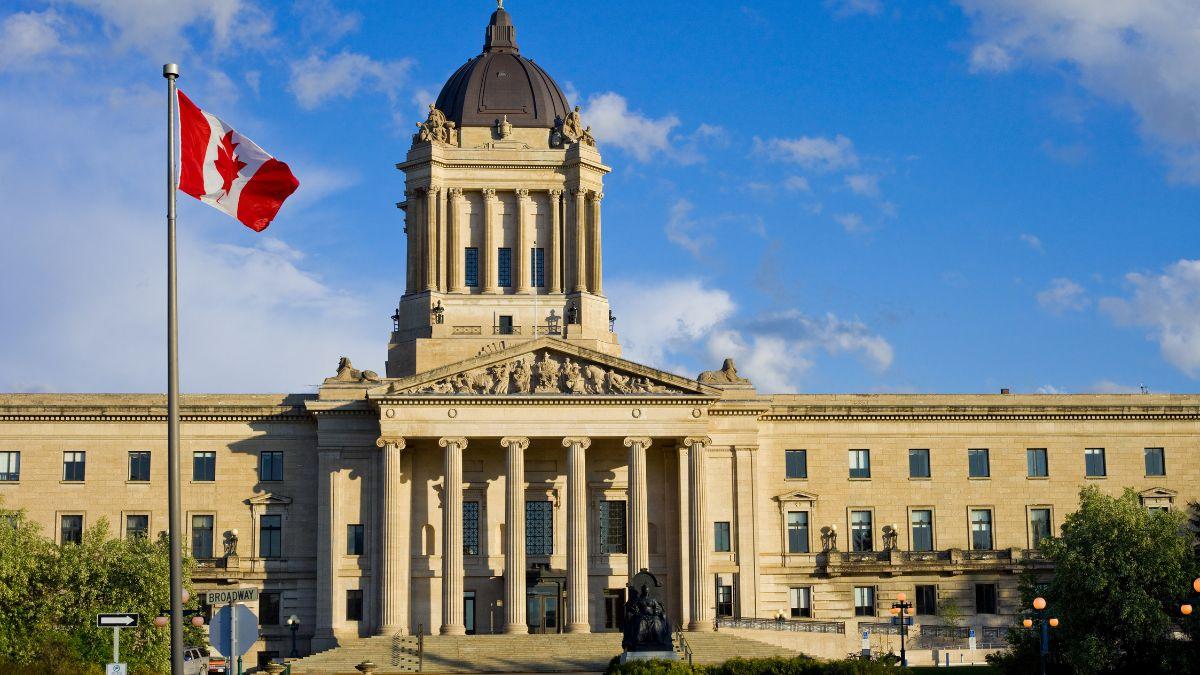 A flag flying in front of Manitoba Legislative Building

Description automatically generated