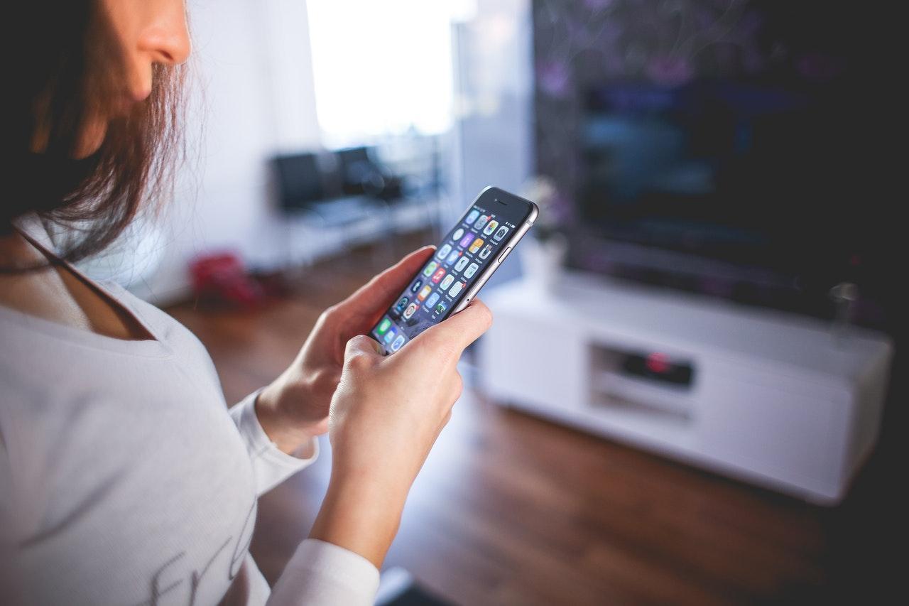 Woman Wearing White V Neck Shirt Using Space Gray Iphone 