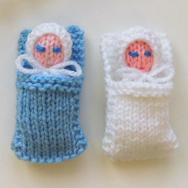 tiny knit baby dolls on white background