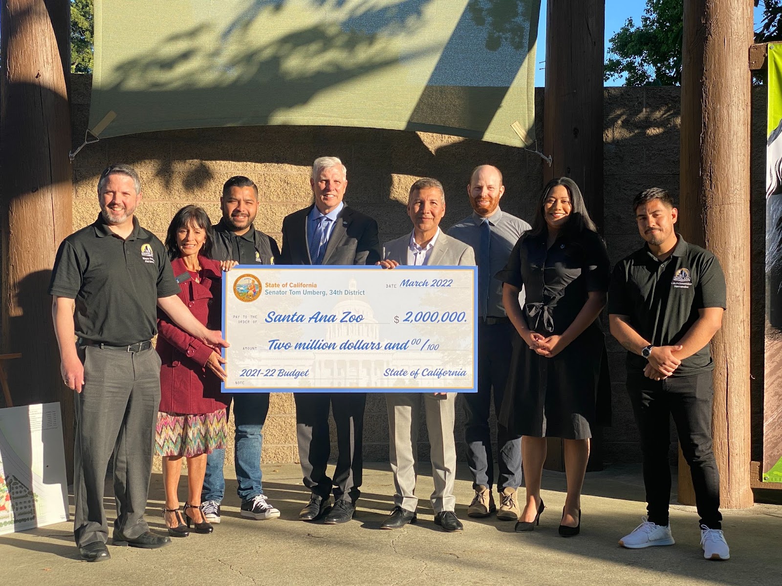 A picture of a group of elected officials holding a check of 2 millions for Santa Ana Zoo