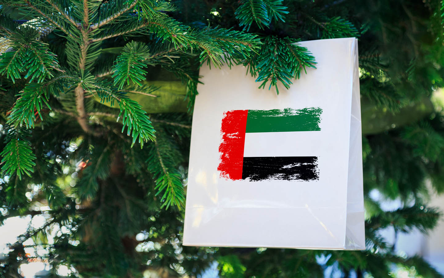 uae flag on gift paper hanging on christmas tree