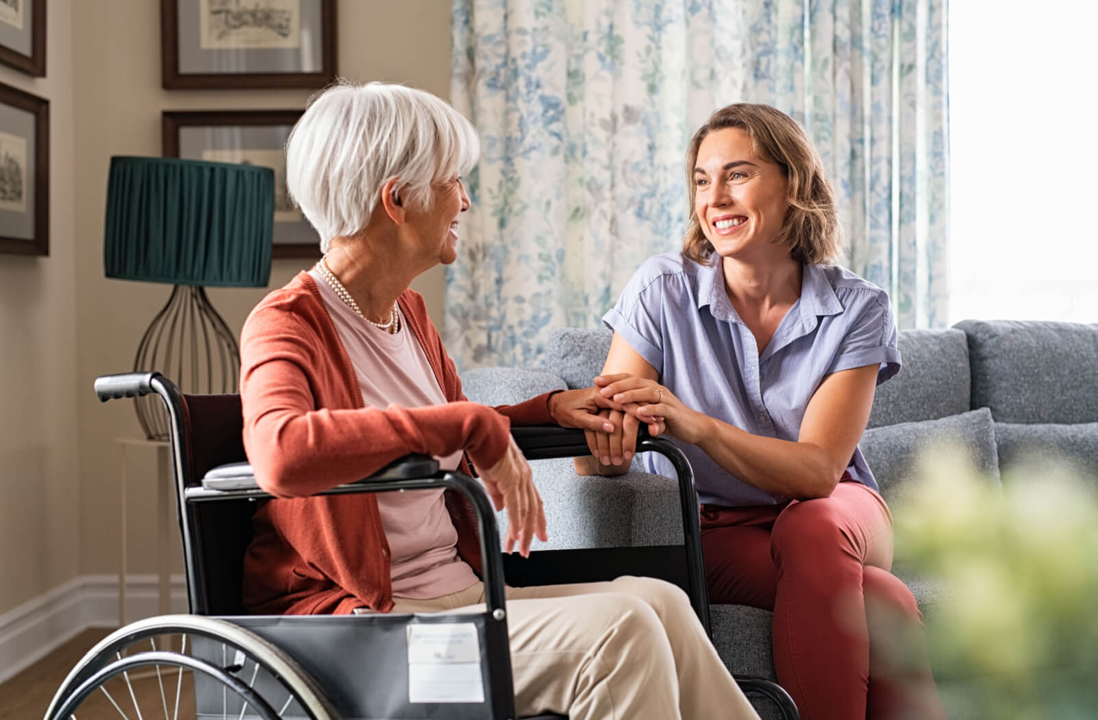 A senior woman with a female caregiver in a senior living community.