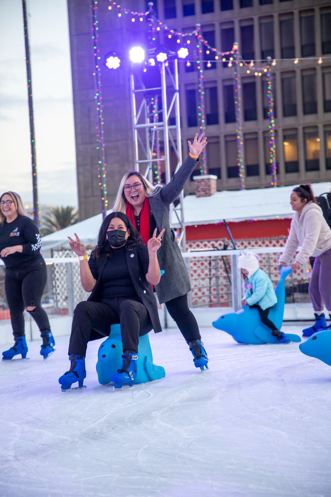 Councilmember Lopez and Phan pose on the ice at the winter village