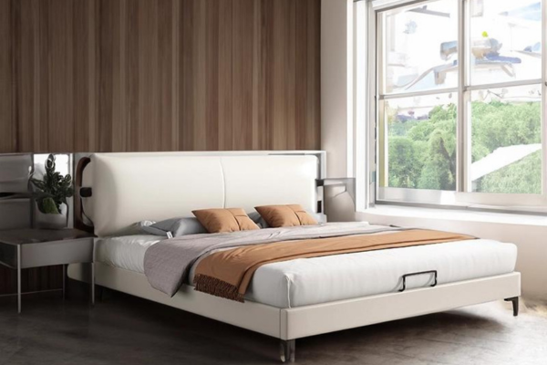 A white queen bed frame upholstered in leatherette with a headboard and steel legs.