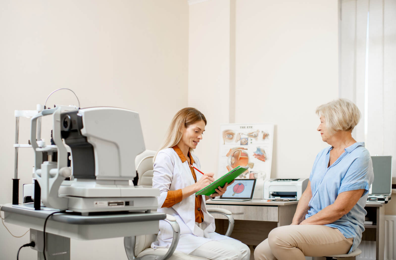 Senior woman talking to a female optometrist eye doctor during annual eye exams consultation.