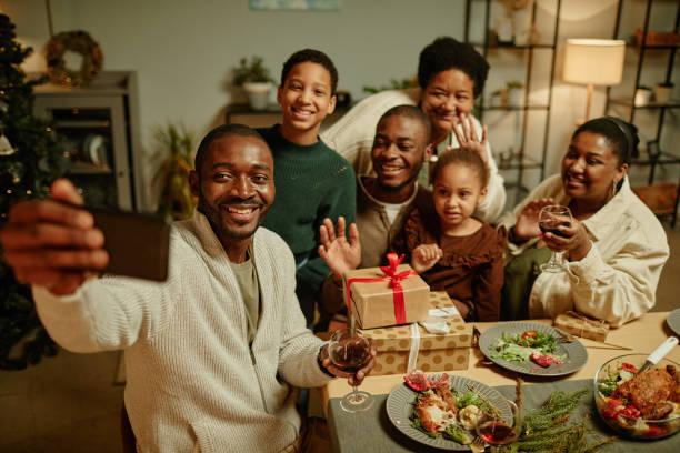African American Family Taking Selfie at Christmas High angle portrait of happy African-American family taking selfie photo while enjoying Christmas at home together Christmas decorations for old people stock pictures, royalty-free photos & images
