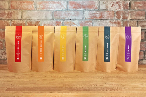 Six bags of coffee with colourful labels.