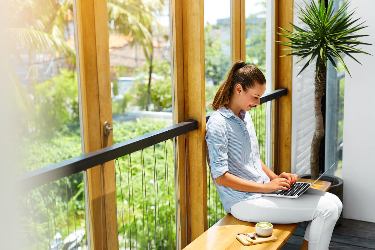 Woman types on laptop in coffee shop