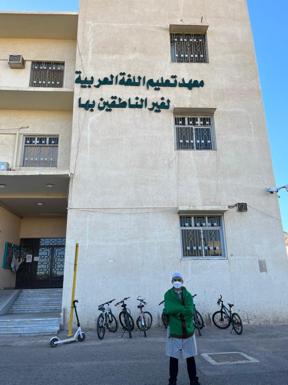A person standing in front of a building with bicycles parked on the side

Description automatically generated with low confidence
