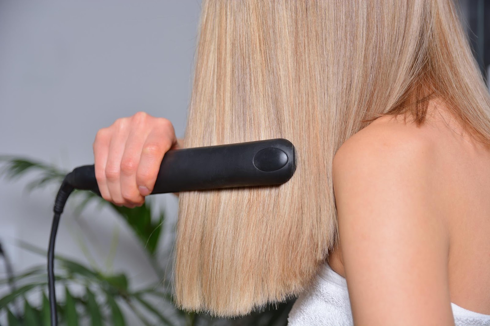 Mulher passando chapinha no cabelo