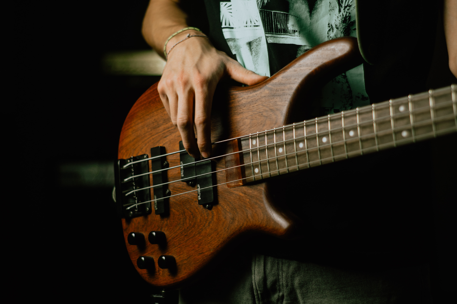 person playing brown bass guitar
