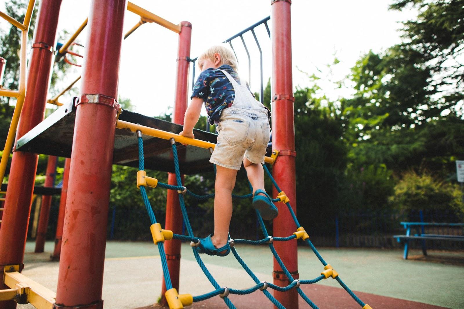 Child climbing on a climbing frame rope ladder