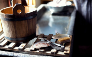 A wooden bucket next to a pile of tools.