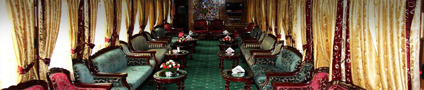 A room with green carpet and tables

Description automatically generated