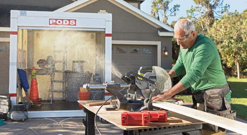 A man using a PODS container to do a laundry room remodel