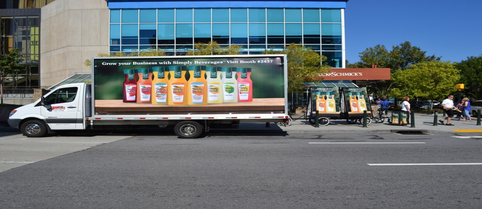 A vibrant delivery truck proudly displaying Tropicana juice products on its side, showcasing a refreshing assortment of flavors and enticing choices.