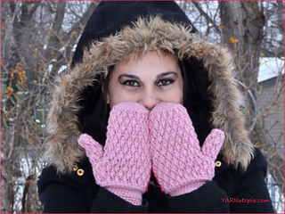 woman modeling pink crochet mittens