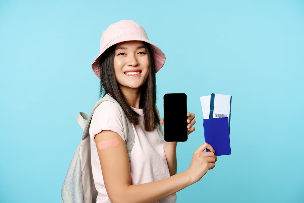 asian woman holding phone, boarding pass, and passport