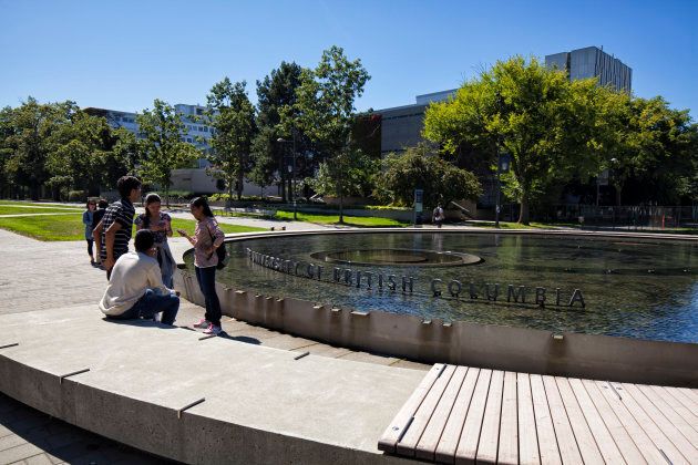 A few students seen in front of a fountain at the University of British Columbia in