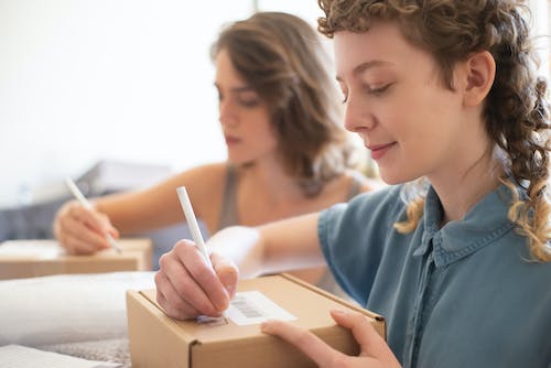 Free Online Sellers Writing Details on the Box Stock Photo