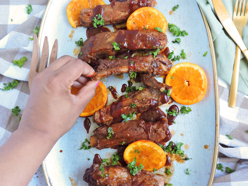 Slow Cooker Bourbon & Orange BBQ Ribs made with the Crock-Pot Express Crock on a platter with orange slices