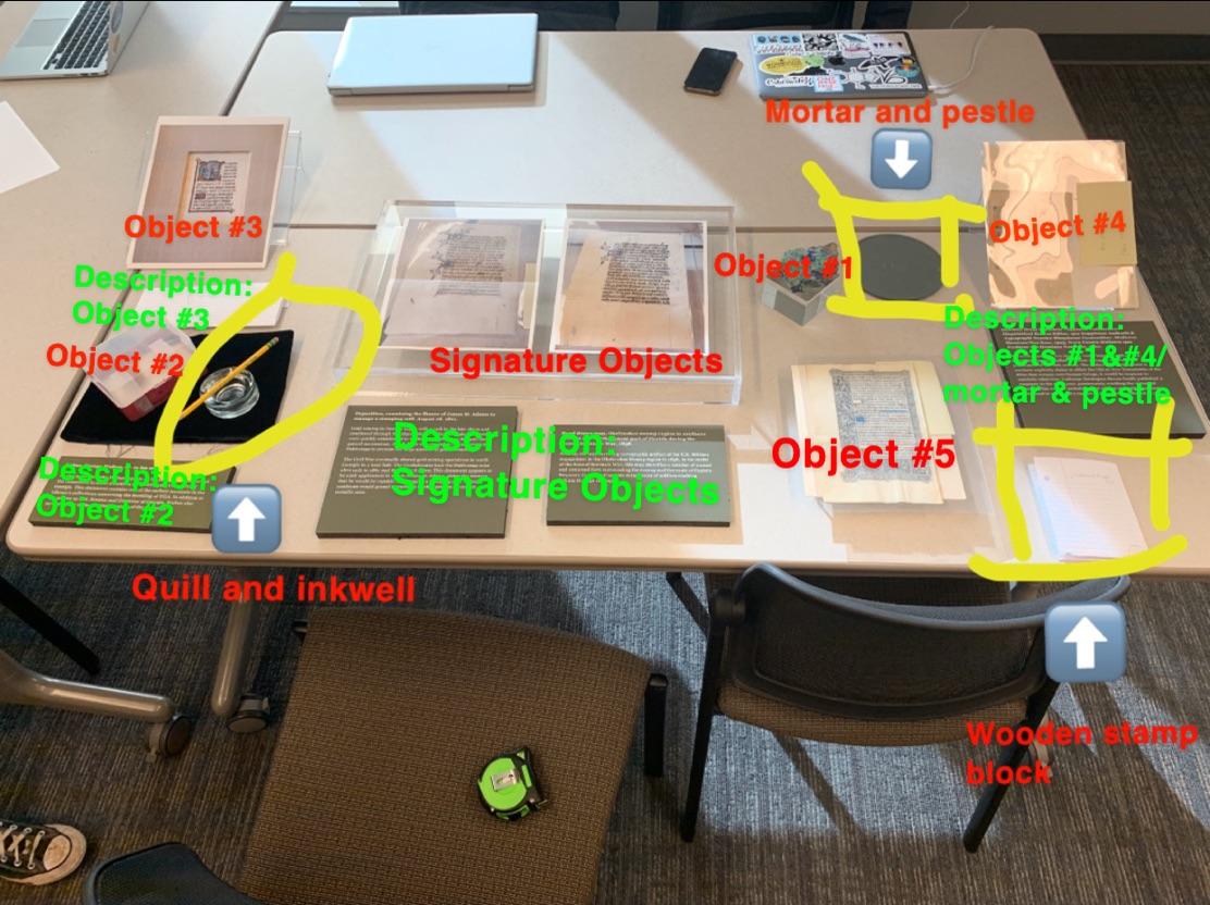 The photo features a mock-up of a case, including two manuscript leaves in the center of the case with large descriptions below them. 