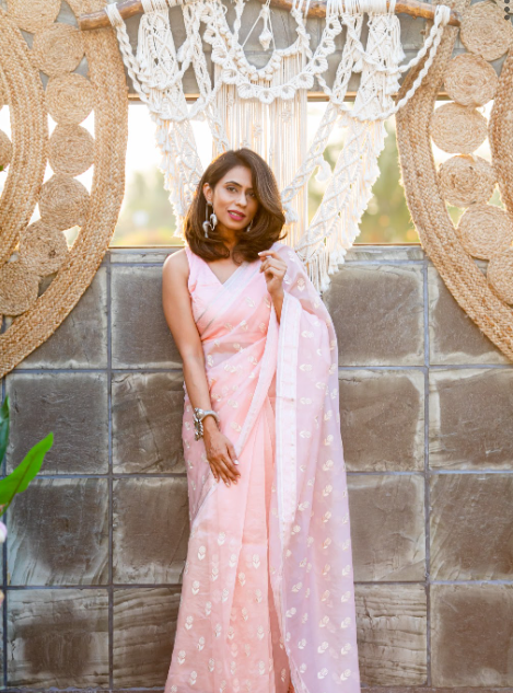 A woman draped into a pink chiniya silk saree with elegant machine embroidery