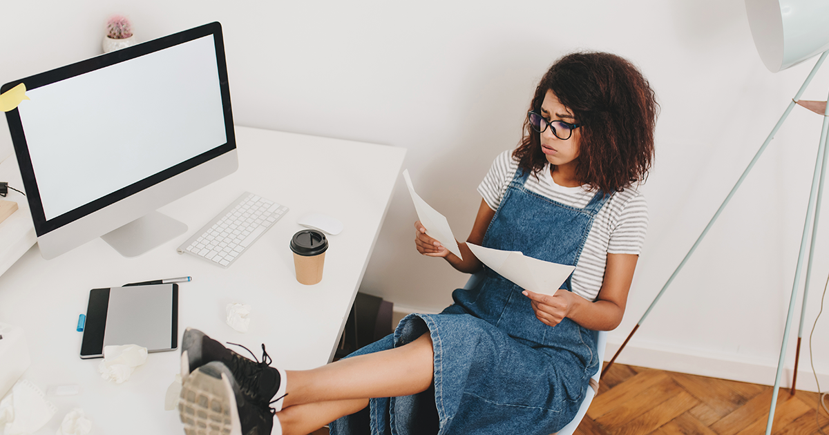 girl working at desk holding paper