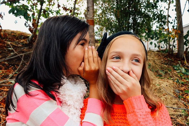 a photo of a young girl whispering to the next person playing the camping game telephone
