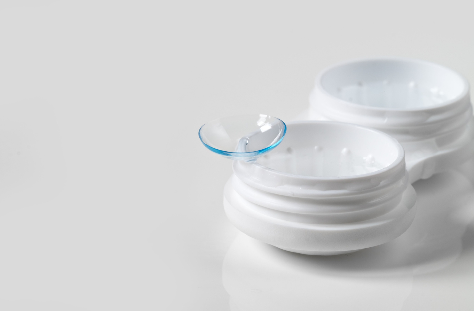 A pair of contact lenses sitting on a contact lens case.
