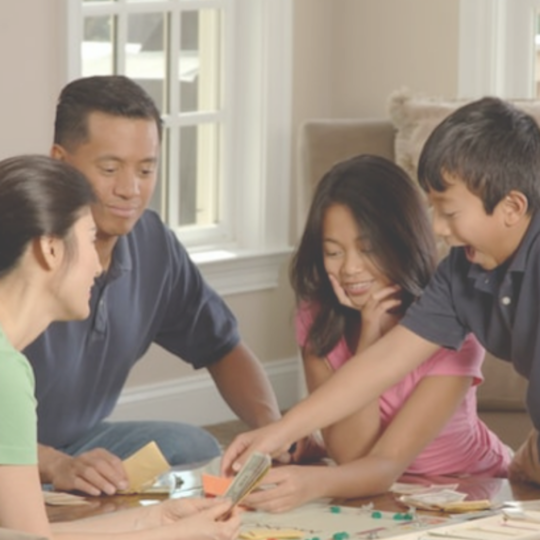 Family of four playing monopoly