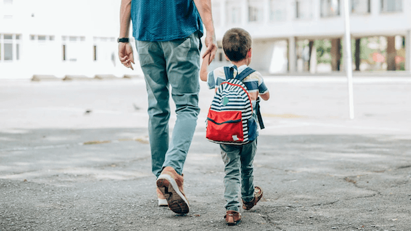 Preschooler and his father heading to school.