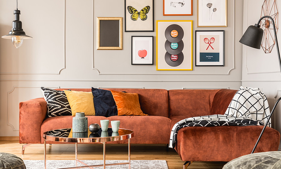 Retro living room with a bright upholstered couch, pillows and picture frames on the wall