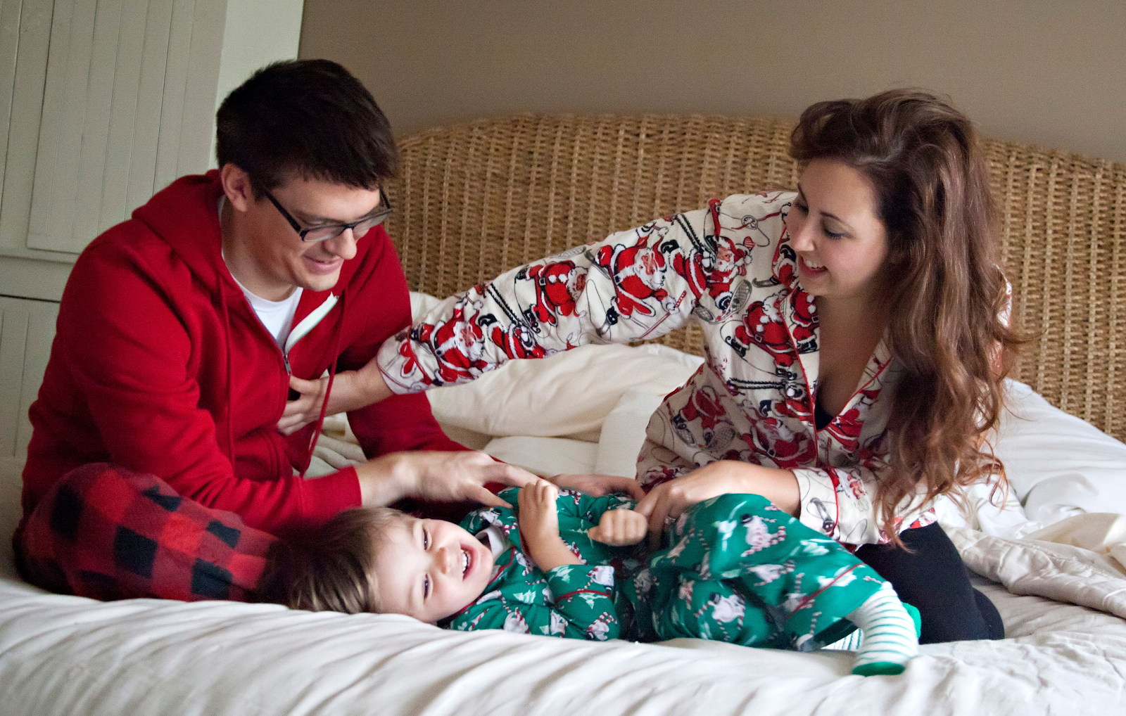 fun christmas card pose of family in bed with holiday pajamas