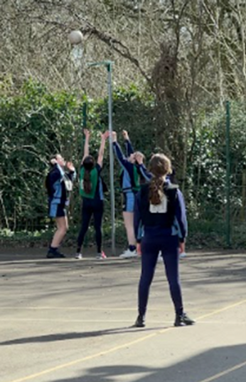 School girls trying to score in netball