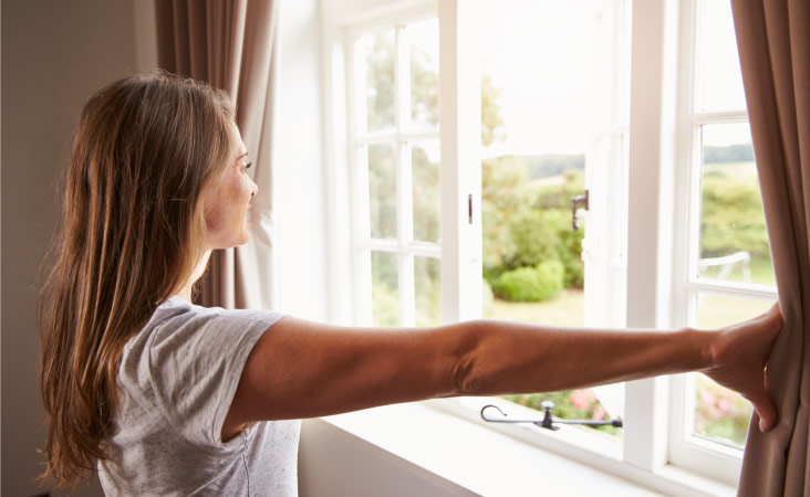 A woman looking out of her feng shui bedroom window