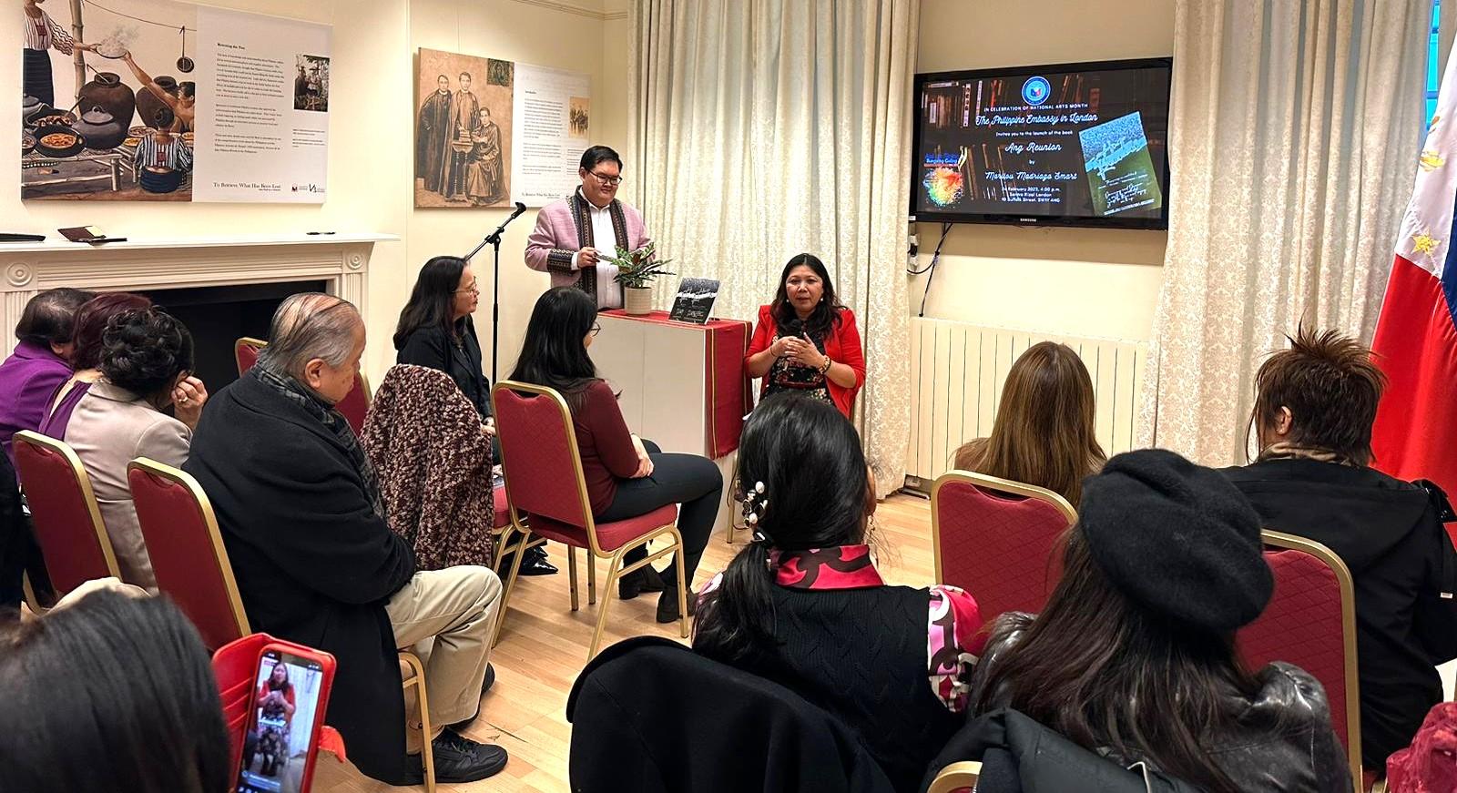 A group of people sitting in a room watching a person play a guitarDescription automatically generated with medium confidence