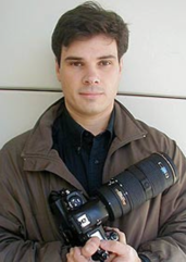 Un hombre con una cámara fotográfica</p>
<p>Descripción generada automáticamente con confianza media