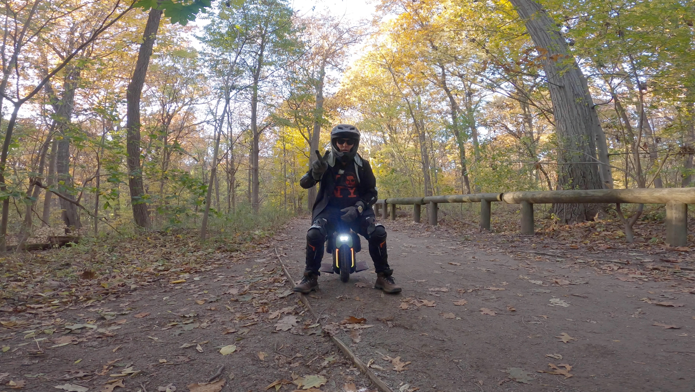 A person riding a motorcycle down a dirt road

Description automatically generated