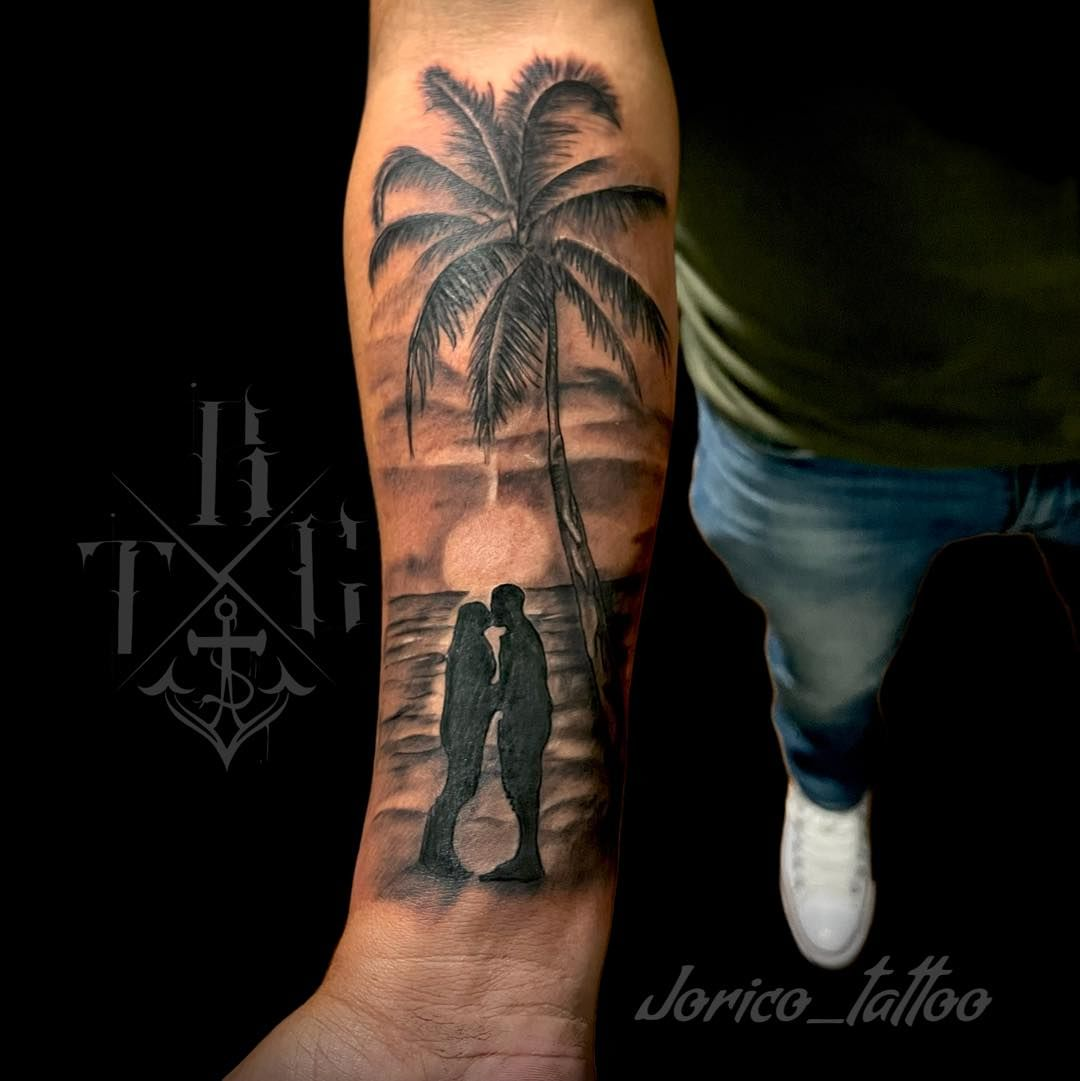 Guy shows off a couple and palm tree tattoo design on his hand