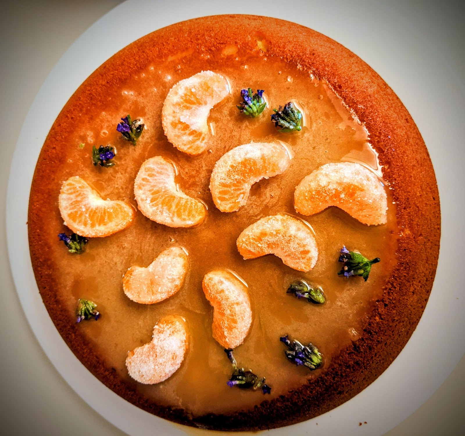 This is a blood-orange olive-oil cake with a lavender-honey and clementine glaze, garnished with sugared clementine segments and glazed lavender blossoms.