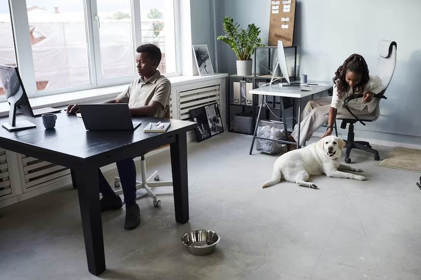 A black lady petting a dog at her desk.
 Image source: Freepik licensed under CC BY-SA 2.0 