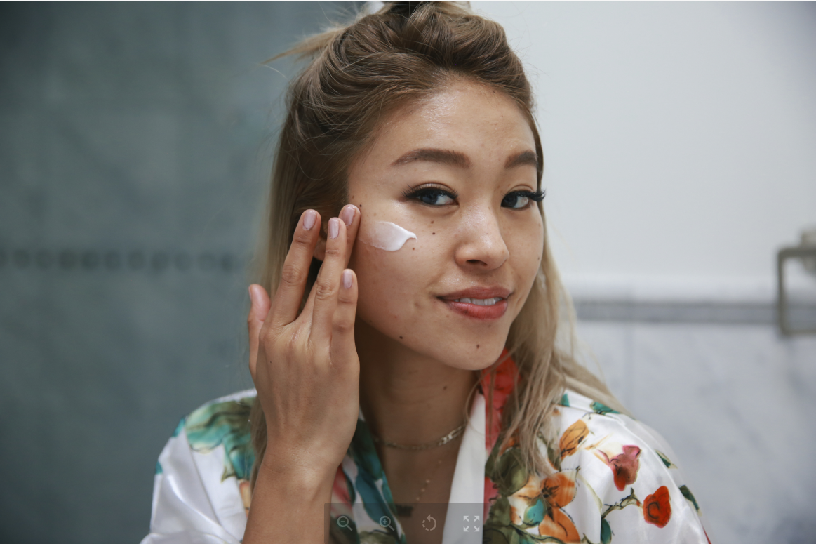 Woman applying face moisturizer 