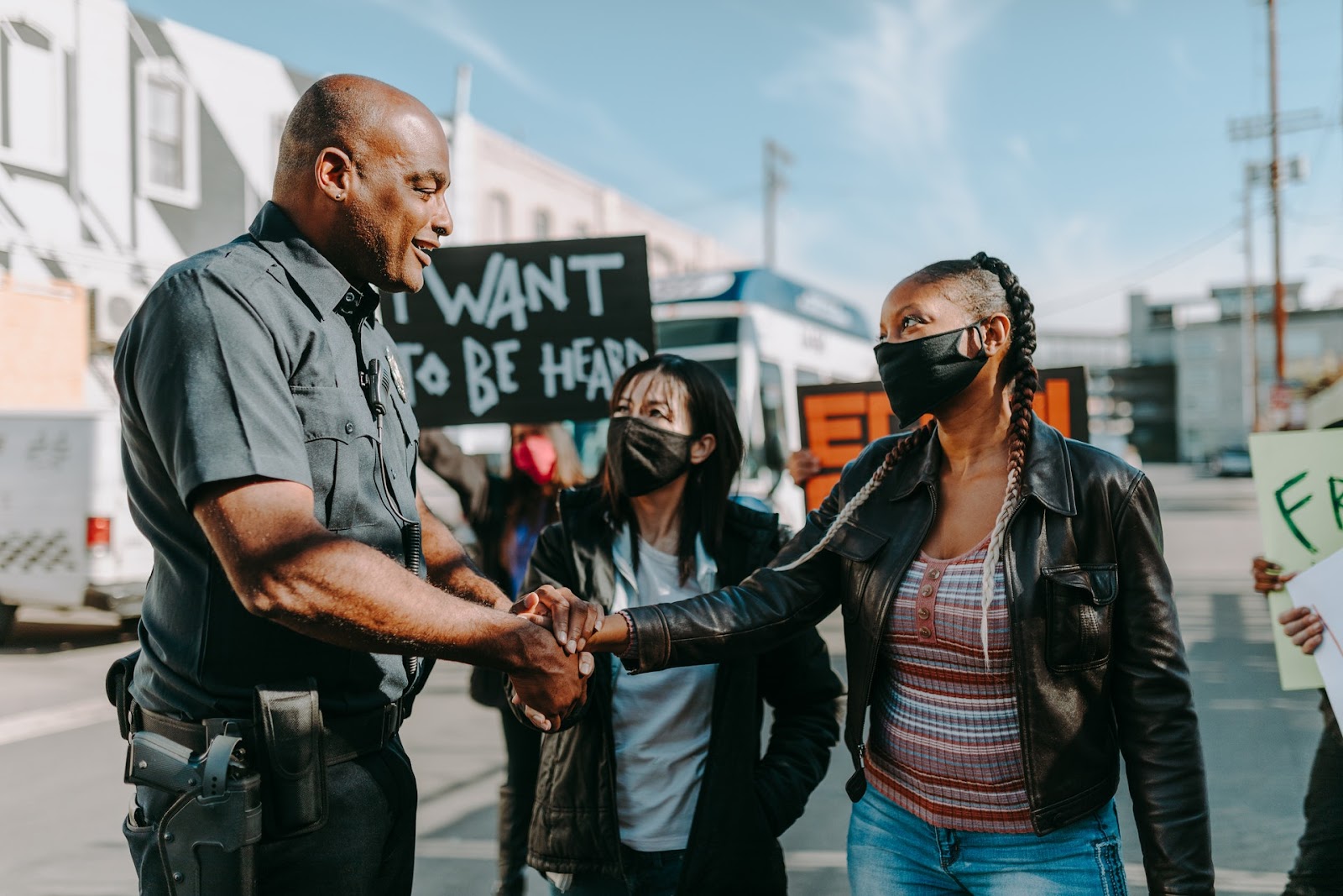 police officer shaking hands with a protester in the street