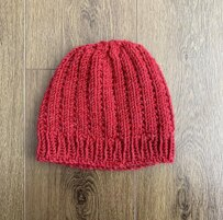 red knit hat lying on wooden floor
