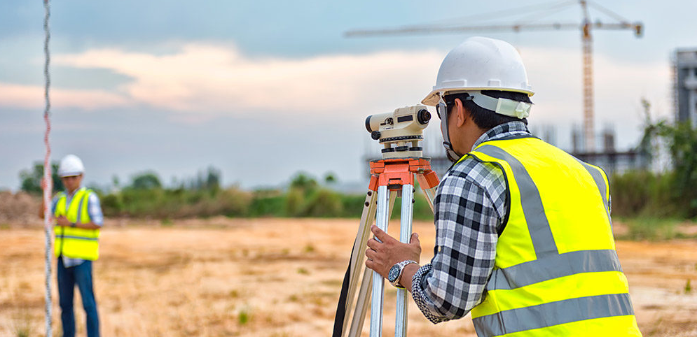 This image shows land surveyors finding the elevation of a job site with an auto level.