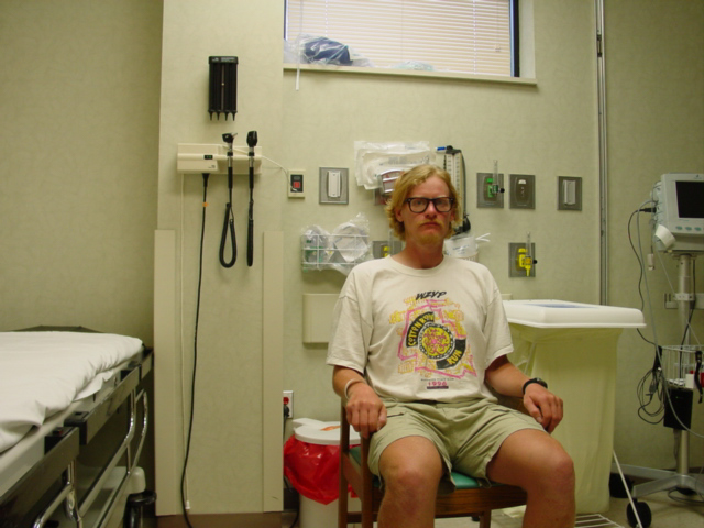 Stern looking man sitting in an ER room.