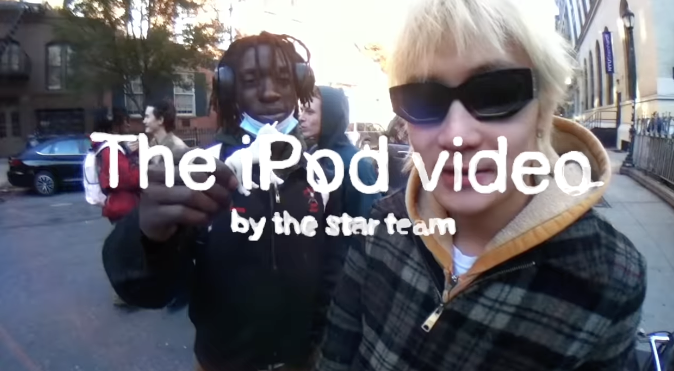 close up of two boys on the street of new york with the words "The iPod Video by the star team" overlayed on top of their faces.