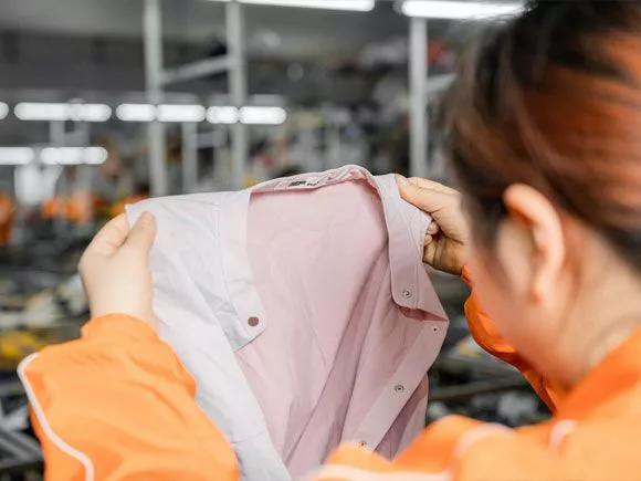 A worker inspecting processed used clothes